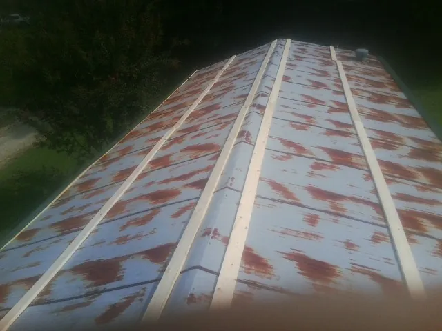 Rusted metal roof panels with new wood purlins before replacement — Storm Damage Roof Repair in Deale by Roofing Brothers