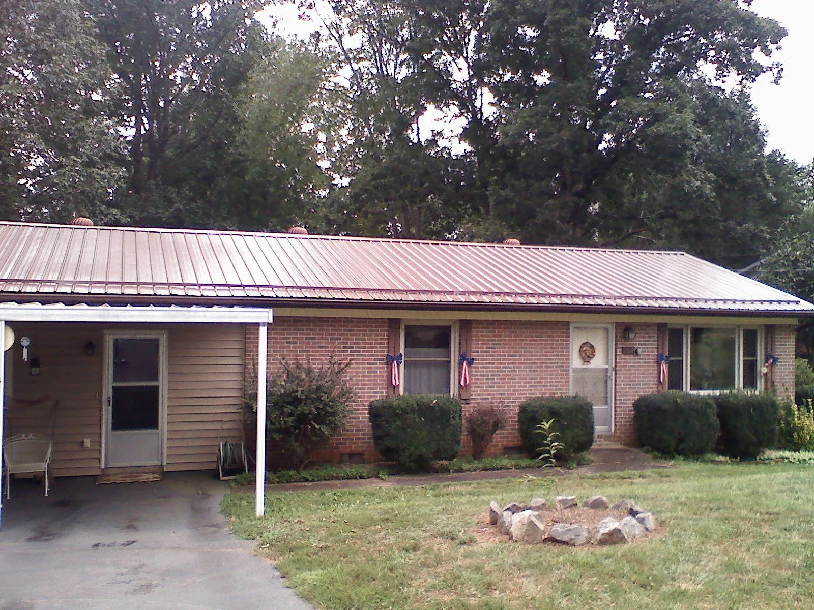 Bronze metal roof and carport on a brick ranch home — Roof Repair work by our crew in Deale